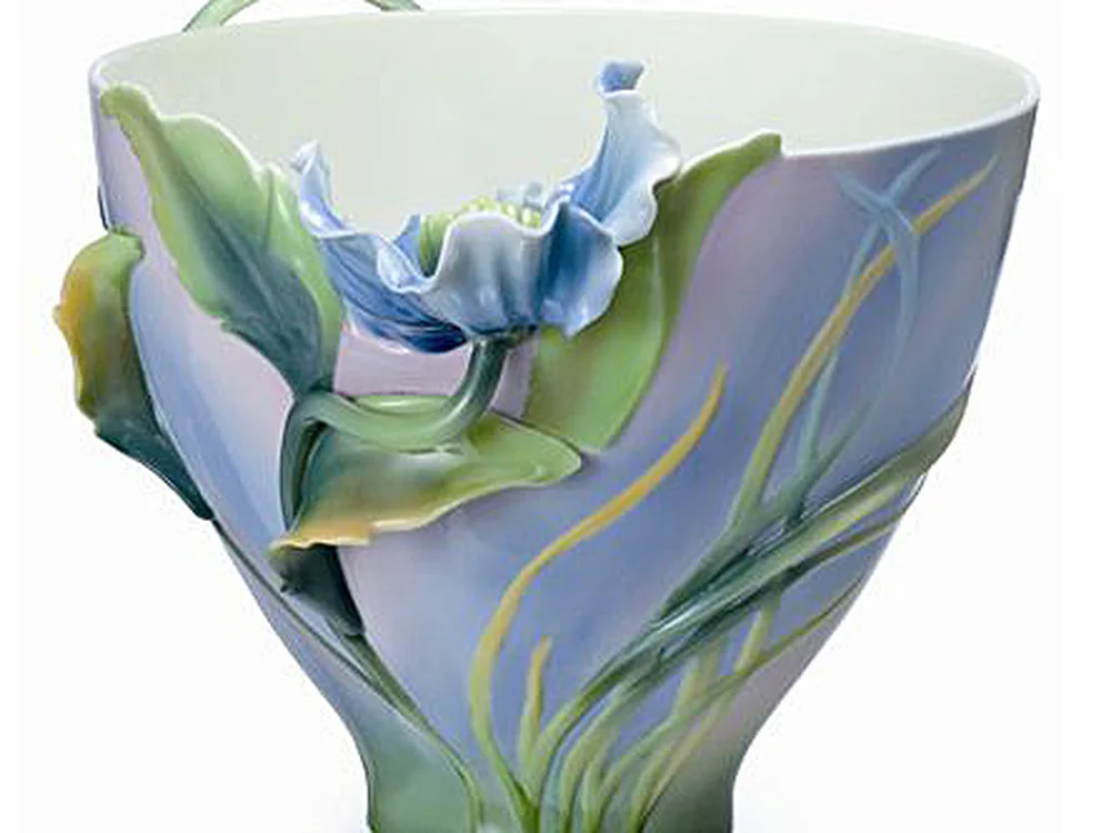 Porcelain cup with a blue-green wash and a sculpted blue bellflower